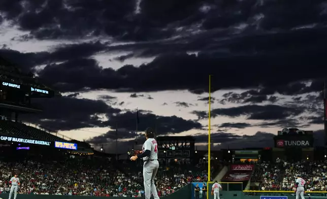 St. Louis Cardinals first baseman Alec Burleson warms up the infielders as clouds roll over Coors Field before the bottom of the fourth inning of a baseball game against the Colorado Rockies Friday, Sept. 4, 2026, in Denver. (AP Photo/David Zalubowski)