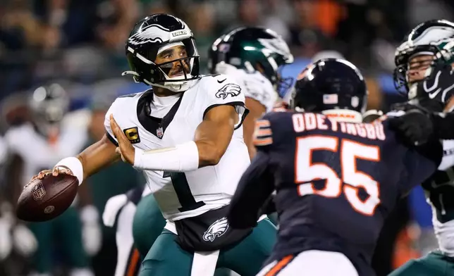 Philadelphia Eagles quarterback Jalen Hurts (1) throws a pass under pressure from Chicago Bears defensive end Dayo Odeyingbo (55) during the first half of an NFL football game in Chicago, Monday, Sept. 28, 2026. (AP Photo/Nam Y. Huh)