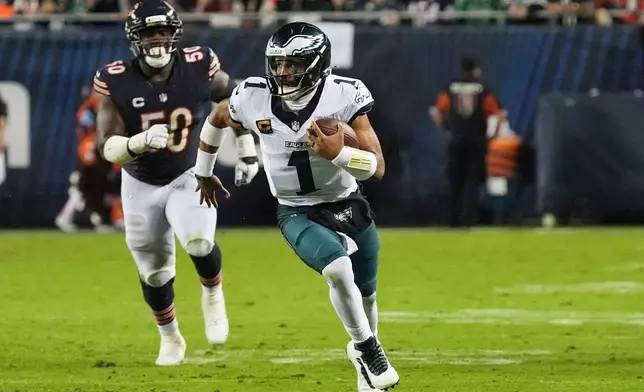 Philadelphia Eagles quarterback Jalen Hurts (1) runs the ball as Chicago Bears defensive end Grady Jarrett (50) gives chase during the second half of an NFL football game in Chicago, Monday, Sept. 28, 2026. (AP Photo/David Banks)