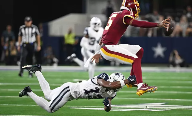 Dallas Cowboys safety Caleb Downs (13) tackles Washington Commanders quarterback Jayden Daniels (5) in the first half during an NFL football game in Arlington, Texas, Sunday, Sept. 20, 2026. (AP Photo/Jessica Tobias)