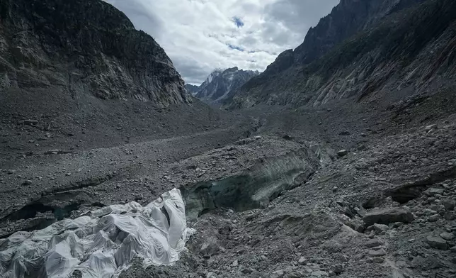 Tarpaulins cover the ice cave of the 'Mer de Glace' glacier to prevent it from melting, at the Montenvers station in Chamonix, France, Saturday, Sept. 5, 2026. (AP Photo/Laurent Cipriani)