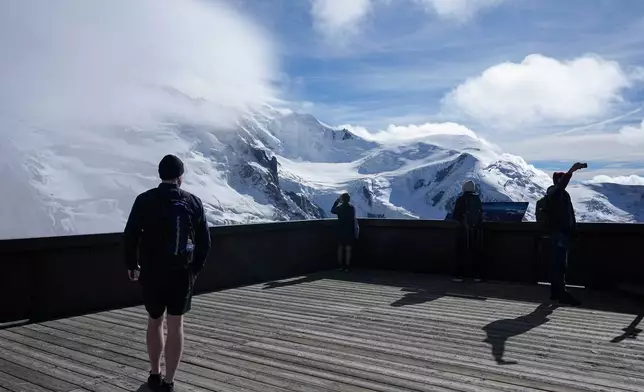 Tourists enjoy the view on the Mont-Blanc massif mountains from the Aiguille du Midi, in Chamonix, France, Saturday, Sept. 5, 2026. (AP Photo/Laurent Cipriani)