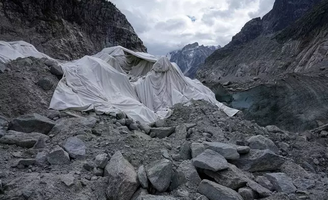 Tarpaulins cover the ice cave of the 'Mer de Glace' glacier to prevent it from melting, at the Montenvers station in Chamonix, France, Saturday, Sept. 5, 2026. (AP Photo/Laurent Cipriani)