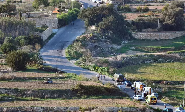 FILE - An ambulance and police vehicles are parked along the road where a car bomb exploded killing investigative journalist Daphne Caruana Galizia, in the town of Mosta, Malta, Oct. 16, 2017. (AP Photo/Rene Rossignaud, File)