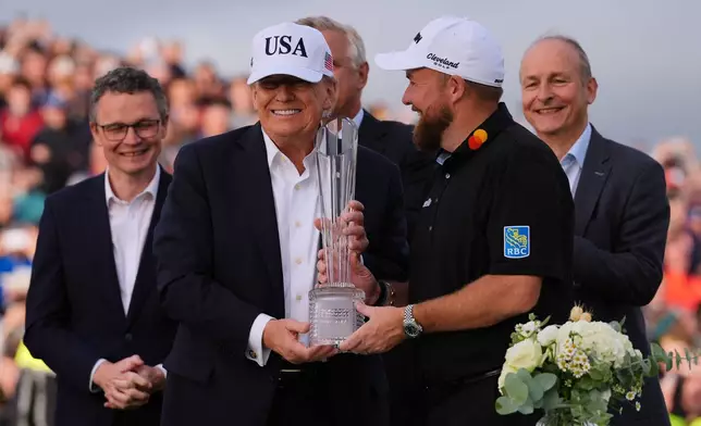 U.S. President Donald Trump, center left, presents the trophy to Shane Lowry of Ireland during the Irish Open golf tournament at Trump International Golf Links in Doonbeg, Ireland, Sunday, Sept. 13, 2026. (AP Photo/Julia Demaree Nikhinson)