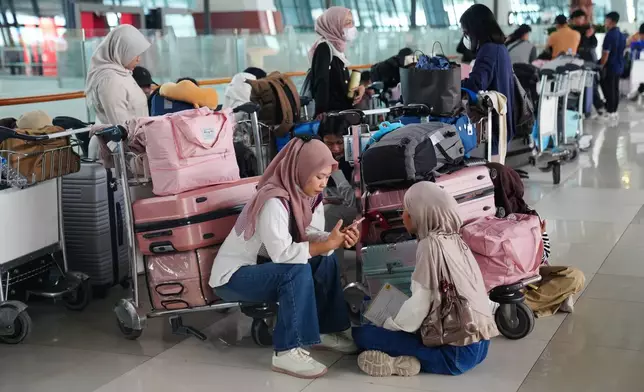 People wait as flights are disrupted due to the eruption of Mount Anak Krakatau, at Soekarno-Hatta International Airport in Tangerang, Indonesia, Monday, Sept. 7, 2026. (AP Photo/Tatan Syuflana)