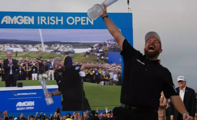 President Donald Trump, right, smiles as Shane Lowry of Ireland celebrates with the trophy after winning the Irish Open golf tournament at Trump International Golf Links in Doonbeg, Ireland, Sunday, Sept. 13, 2026. (AP Photo/Julia Demaree Nikhinson)