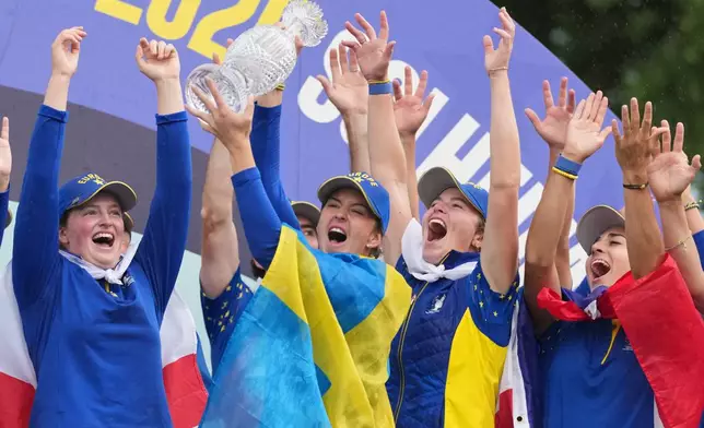 Linn Grant of Europe holds the trophy as she celebrates with teammates after they won the Solheim Cup in Den Bosch, Netherlands, Sunday, Sept. 13, 2026. (AP Photo/Alastair Grant)
