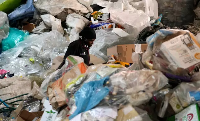 A worker sorts recyclable items in a pile of garbage at the Whole Earth Recycling in Johannesburg, South Africa, Tuesday, July 28, 2026. (AP Photo/Themba Hadebe)