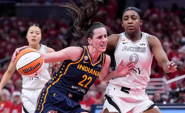 Indiana Fever guard Caitlin Clark (22) drives on Las Vegas Aces guard Jackie Young (0) during the first half in Game 2 of a WNBA basketball first-round playoff series in Indianapolis, Tuesday, Sept. 29, 2026. (AP Photo/Michael Conroy)