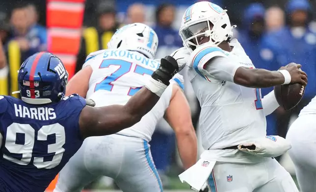 New York Giants defensive tackle Shelby Harris (93) grabs the facemask of Tennessee Titans quarterback Cam Ward (1) during the second half of an NFL football game in East Rutherford, N.J., Sunday, Sept. 27, 2026. (AP Photo/Frank Franklin II)