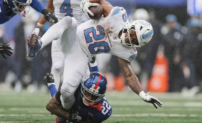 New York Giants cornerback Dru Phillips (22) tackles Tennessee Titans running back Tony Pollard (20) during the second half of an NFL football game in East Rutherford, N.J., Sunday, Sept. 27, 2026. (AP Photo/Adam Hunger)