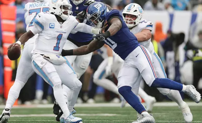 New York Giants linebacker Brian Burns (0) pressures Tennessee Titans quarterback Cam Ward (1) during the first half of an NFL football game in East Rutherford, N.J., Sunday, Sept. 27, 2026. (AP Photo/Adam Hunger)