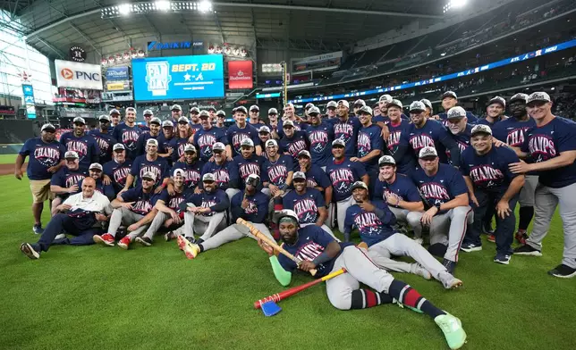Atlanta Braves players and coaches take a group photo on the field after a baseball game against the Houston Astros as the Braves clinched the NL East title, Sunday, Sept. 20, 2026, in Houston. (AP Photo/Karen Warren)