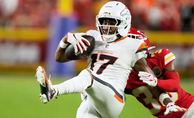 Denver Broncos wide receiver Jaylen Waddle (17) is brought down by Kansas City Chiefs cornerback L'jarius Sneed (38) after catching a pass during the first half of an NFL football game Monday, Sept. 14, 2026, in Kansas City, Mo. (AP Photo/Charlie Riedel)