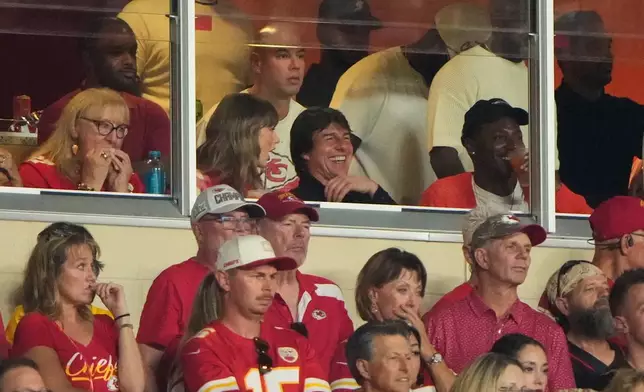 Taylor Swift, left, sits with Tom Cruise, center, while watching the first half of an NFL football game between the Kansas City Chiefs and the Denver Broncos, Monday, Sept. 14, 2026, in Kansas City, Mo. (AP Photo/Charlie Riedel)
