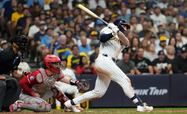 Milwaukee Brewers' Garrett Mitchell, right, watches his two-run double during the fifth inning of a baseball game against the Cincinnati Reds, Saturday, Sept. 12, 2026, in Milwaukee. (AP Photo/Aaron Gash)