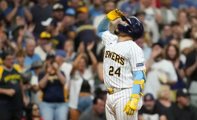Milwaukee Brewers' William Contreras gestures as he rounds the bases after hitting a three-run home run during the fourth inning of a baseball game against the Cincinnati Reds, Saturday, Sept. 12, 2026, in Milwaukee. (AP Photo/Aaron Gash)