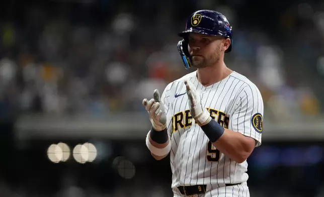 Milwaukee Brewers' Jake Bauers claps after hitting a two-run single during the fifth inning of a baseball game against the Cincinnati Reds, Saturday, Sept. 12, 2026, in Milwaukee. (AP Photo/Aaron Gash)