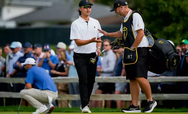 International teams' Min Woo Lee, of Australia, celebrates his birdie on the second hole with his caddie during the first round four-ball match at the Presidents Cup golf tournament at Medinah Country Club, Thursday, Sept. 24, 2026, in Medinah, Ill. (AP Photo/Matt Slocum)