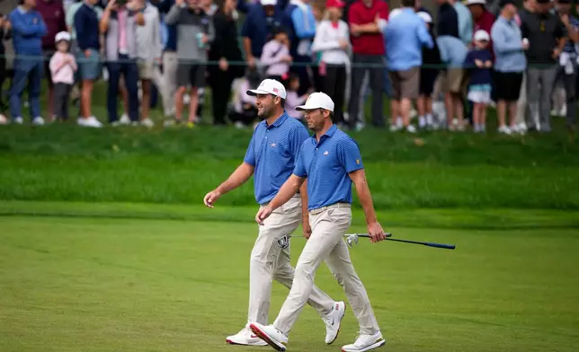 USA teams' Scottie Scheffler and Sam Burns, right, walk up the first fairway during the first round four-ball match at the Presidents Cup golf tournament against the International team at Medinah Country Club, Thursday, Sept. 24, 2026, in Medinah, Ill. (AP Photo/Matt Slocum)