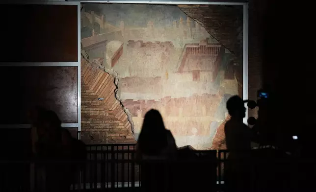 Reporters film the "The Painted City" fresco, discovered during 1990s built as foundations for the Baths of Trajan that has been restored, in Rome, Tuesday, Sept. 8, 2026.(AP Photo/Andrew Medichini)