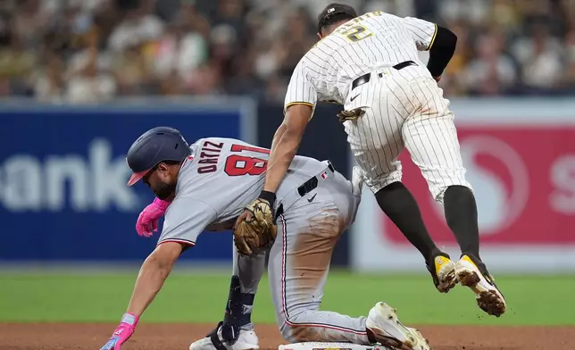 San Diego Padres shortstop Xander Bogaerts (2) applies the tag too late as Washington Nationals' Abimelec Ortiz arrives safely to second base with a double during the sixth inning of a baseball game Tuesday, Sept. 8, 2026, in San Diego. (AP Photo/Gregory Bull)