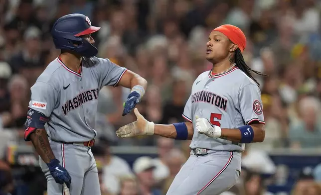 Washington Nationals' CJ Abrams, right, celebrates with teammate Daylen Lile after scoring on a two-RBI double by Brady House during the sixth inning of a baseball game Tuesday, Sept. 8, 2026, in San Diego. (AP Photo/Gregory Bull)