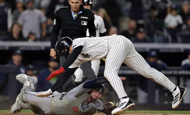 New York Yankees' George Lombard Jr. avoids a tag from Tampa Bay Rays catcher Liam Hicks to score a run during the seventh inning of a baseball game Thursday, Sept. 24, 2026, in New York. (AP Photo/Adam Hunger)