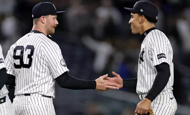 New York Yankees pitcher Bradley Hanner (93) celebrates with George Lombard Jr., right, after their team defeated the Tampa Bay Rays in a baseball game Thursday, Sept. 24, 2026, in New York. (AP Photo/Adam Hunger)
