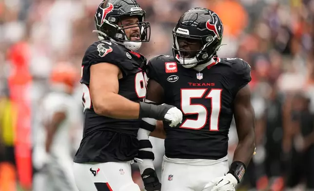 Houston Texans defensive end Logan Hall (96), and defensive end Will Anderson Jr. (51), celebrate after sacking Cincinnati Bengals quarterback Joe Burrow during the first half of an NFL football game in Houston, Sunday, Sept. 20, 2026. (AP Photo/Ashley Landis)