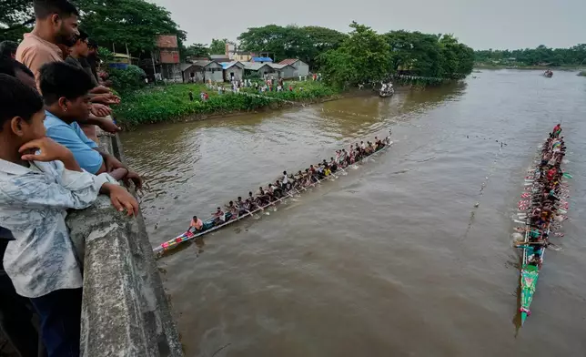 Villagers watch as participants take part in the traditional boat race on the Kulsi river in Champupara village, west of Guwahati, India, Thursday, Sept. 17, 2026. (AP Photo/Anupam Nath)