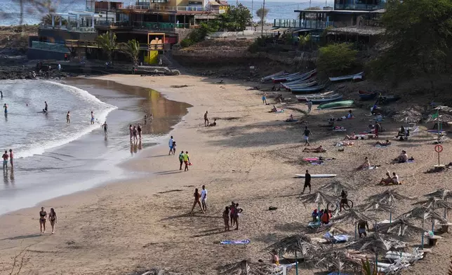 FILE - People lounge on a beach in Praia, Cape Verde, on May 7, 2026. (AP Photo/Misper Apawu, File)