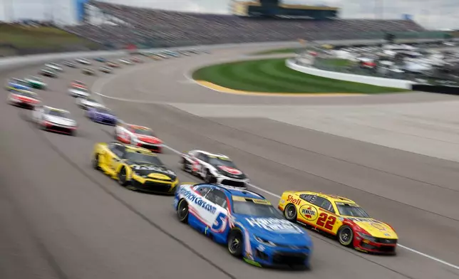Kyle Larson (5) and Joey Logano (22) lead the field into Turn 1 during the start of a NASCAR Cup Series auto race at Kansas Speedway in Kansas City, Kan., Sunday, Sept. 27, 2026. (AP Photo/Colin E. Braley)
