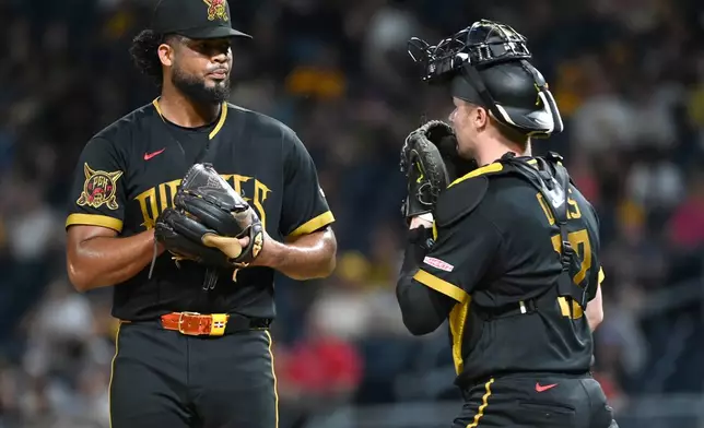 Pittsburgh Pirates relief pitcher Wilber Dontel (left) gets a mound visit from catcher Henry Davis as they play the Los Angeles Angels during the seventh inning of a baseball game, Friday, Sept. 4, 2026, in Pittsburgh. (AP Photo/Philip G. Pavely)