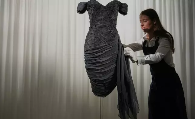 A dress worn by the late Princess Diana and known as the ''Revenge Dress'', designed by Christina Stambolian, is unveiled by staff at Sotheby’s auction house in London, Friday, Sept. 18, 2026, ahead of its Dec. 9 auction in New York, where it is estimated to sell for US$150,000-300,000. (AP Photo/Alastair Grant)