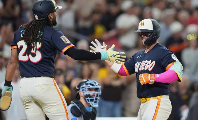 San Diego Padres' Ty France, right, celebrates with Fernando Tatis Jr. after hitting a three-run home run during the fifth inning of a baseball game against the Miami Marlins Friday, Sept. 18, 2026, in San Diego. (AP Photo/Gregory Bull)