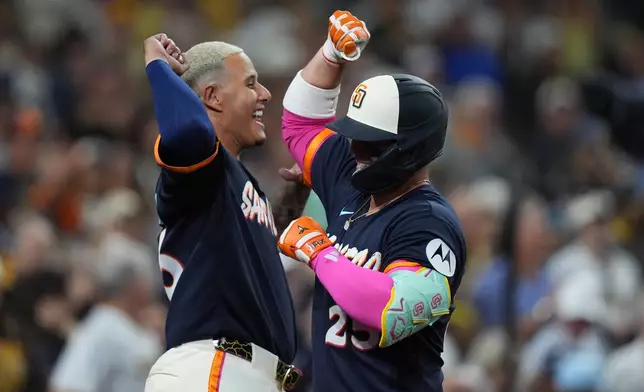 San Diego Padres' Ty France, right, celebrates with teammate Manny Machado after hitting a three-run home run during the fifth inning of a baseball game against the Miami Marlins Friday, Sept. 18, 2026, in San Diego. (AP Photo/Gregory Bull)