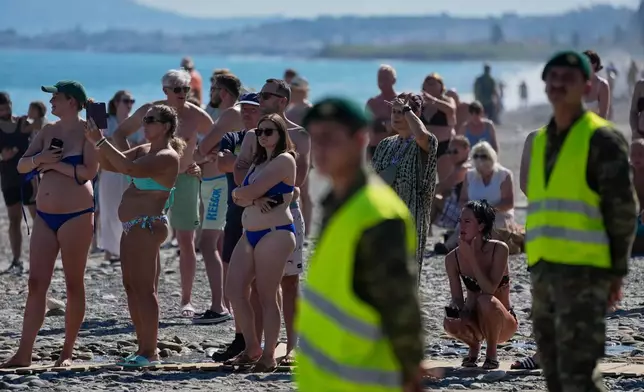 Tourists from nearby hotels watch Medusa 15, a multinational military exercise led by Greece and Egypt, at Maleme on the Greek island of Crete, Friday, Sept. 18, 2026. (AP Photo/Thanassis Stavrakis)