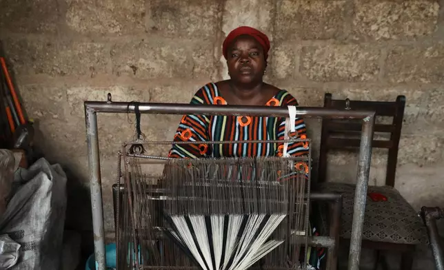 Chabi Baké, a mother of five, is photographed behind a weaving machine in Parakou, northern Benin, Saturday, May 16, 2026. (AP Photo/Sunday Alamba)