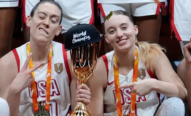 Breanna Stewart, of the United States,, left, and Paige Bueckers pose with trophy after the Women's Basketball World Cup final match between the United States and France in Berlin, Sunday, Sept. 13, 2026. (AP Photo/Ebrahim Noroozi)