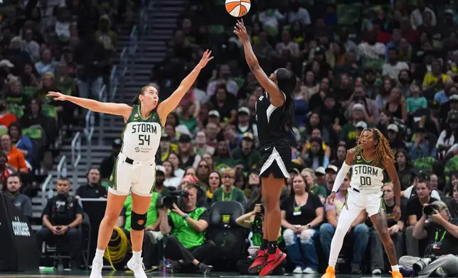 Las Vegas Aces guard Jackie Young jumps to make a basket against Seattle Storm forward Mackenzie Holmes (54) during the first half of a WNBA basketball game, Thursday, Sept. 17, 2026, in Seattle. (AP Photo/Lindsey Wasson)