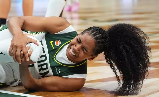 Seattle Storm guard Zia Cooke holds her knee after going down during the first half of a WNBA basketball game against the Las Vegas Aces, Thursday, Sept. 17, 2026, in Seattle. (AP Photo/Lindsey Wasson)