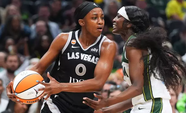 Las Vegas Aces guard Jackie Young, left, looks around the defense of Seattle Storm guard Flau'jae Johnson, right, during the first half of a WNBA basketball game, Thursday, Sept. 17, 2026, in Seattle. (AP Photo/Lindsey Wasson)