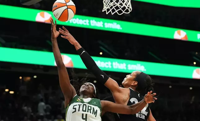 Las Vegas Aces center A'ja Wilson knocks the ball away from Seattle Storm guard Flau'jae Johnson (4) at the basket during the first half of a WNBA basketball game, Thursday, Sept. 17, 2026, in Seattle. (AP Photo/Lindsey Wasson)