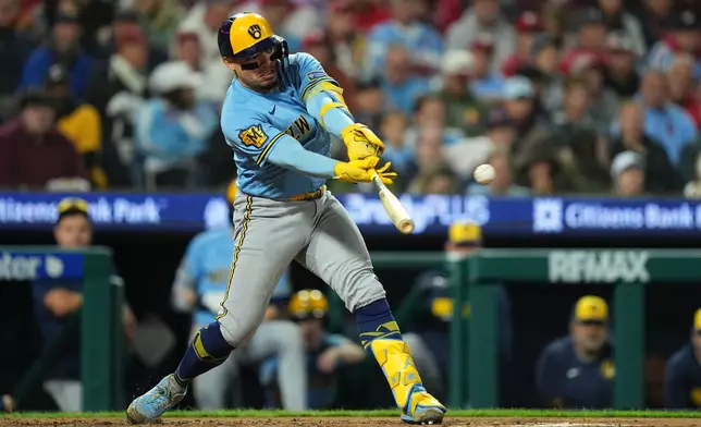 Milwaukee Brewers' William Contreras hits a sacrifice fly off of Philadelphia Phillies pitcher Zack Wheeler during the fourth inning of a baseball game, Tuesday, Sept. 22, 2026, in Philadelphia. (AP Photo/Matt Rourke)