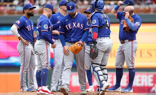 Texas Rangers pitcher Jakob Junis, center, reacts after he is taken out of the game against the Minnesota Twins during the fifth inning of a baseball game, Sunday, Sept. 27, 2026, in Minneapolis. (AP Photo/Matt Krohn)