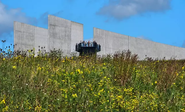 Visitors to the Flight 93 National Memorial in Shanksville, Pa., on Friday, Sept.11, 2026, view the memorial park below from the plane's flight path marked by the separation in the building, as the nation marks the 25th anniversary of the Sept. 11, 2001, attacks. (AP Photo/Gene J. Puskar)