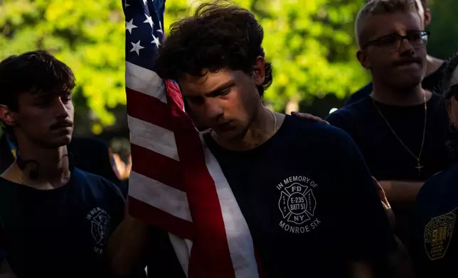 Family of Dennis Cross, a battalion chief who died during 9/11, finish walking 53 miles in Cross' honor as they arrive at the 9/11 Memorial Pools on the 25th anniversary of the September 11 World Trade Center attacks, Friday, Sept. 11, 2026, in New York. (AP Photo/Angelina Katsanis)