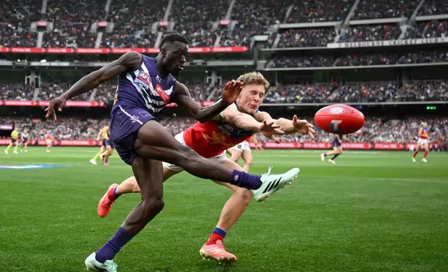 Jaspa Fletcher of the Brisbane Lions, right, attempts to smother a kick by Michael Frederick of the Fremantle Dockers during the Australian Football League grand final in Melbourne, Australia Saturday, Sept. 26, 2026. (Joel Carrett/AAP Image via AP)